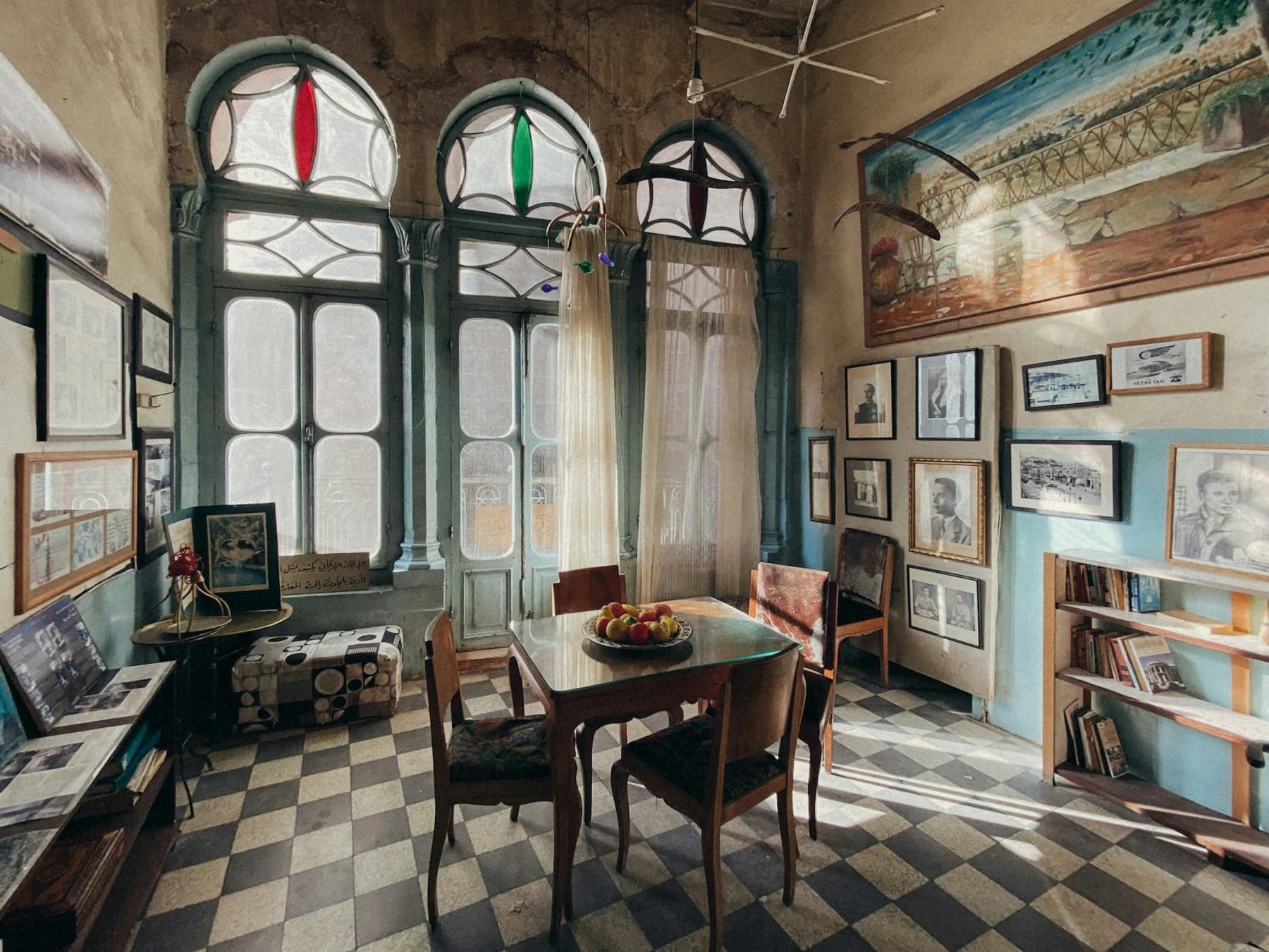 Sala eclettica con vetrate colorate e arredi mescolati di epoche diverse
