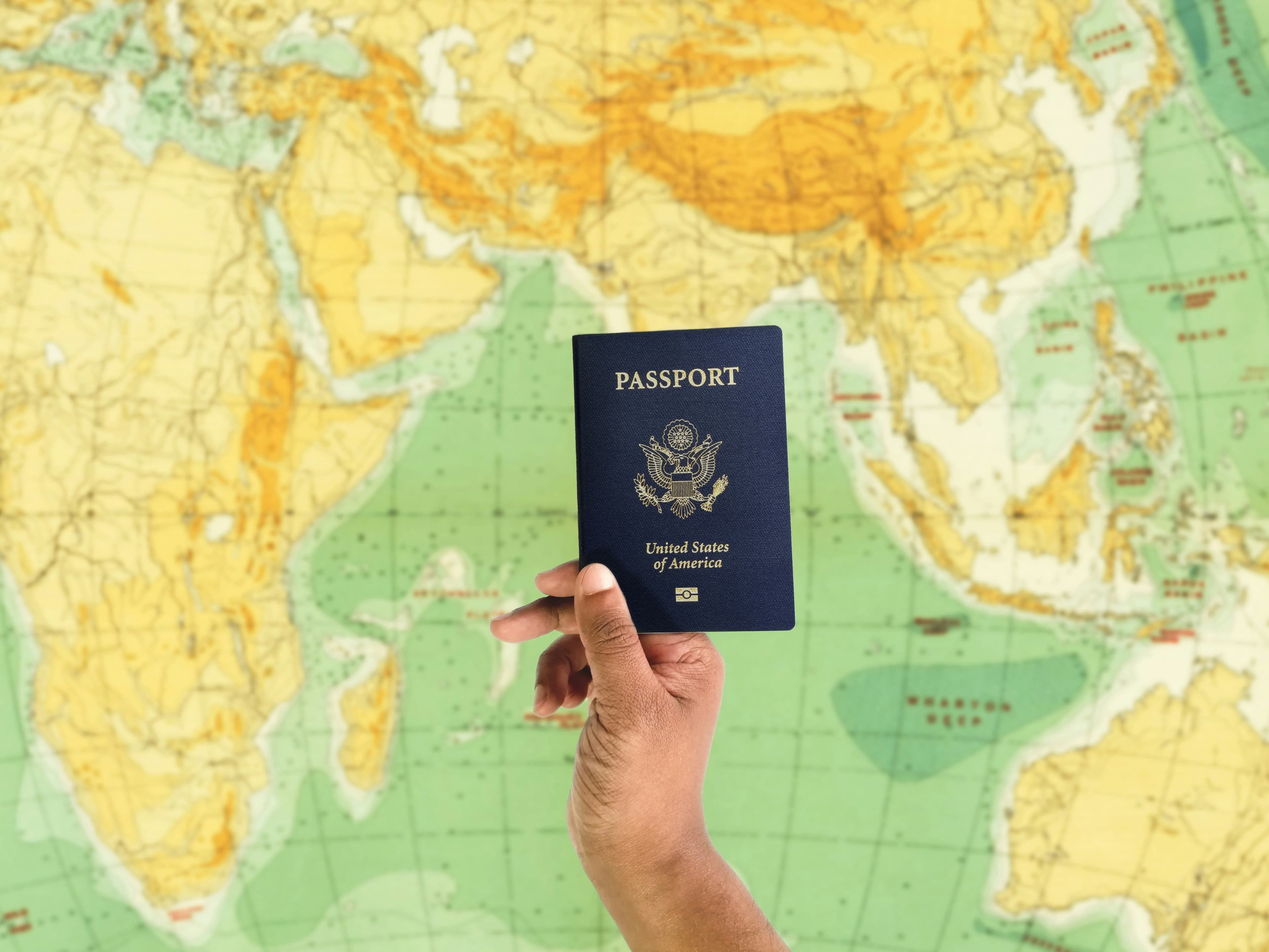 Un passaporto americano davanti a un planisfero, pianificando il trasferimento dall'America all'Italia